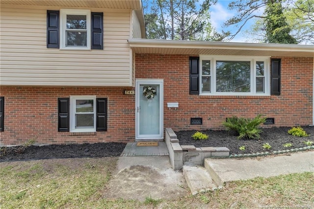 view of front of home with crawl space and brick siding