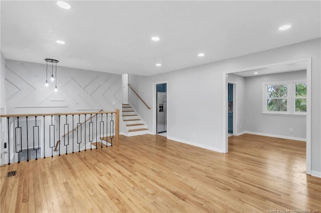 interior space featuring baseboards, light wood finished floors, and recessed lighting