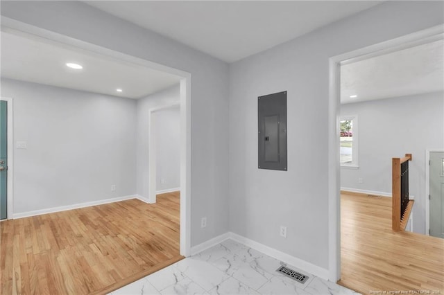 unfurnished room with marble finish floor, recessed lighting, baseboards, and electric panel