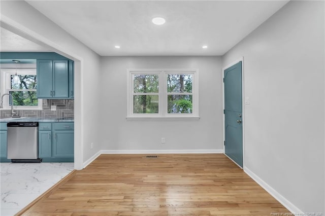 unfurnished dining area featuring marble finish floor, a sink, baseboards, and recessed lighting