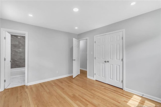 unfurnished bedroom with light wood-style flooring, baseboards, and recessed lighting