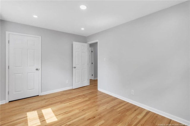 unfurnished bedroom featuring baseboards, light wood-style floors, and recessed lighting
