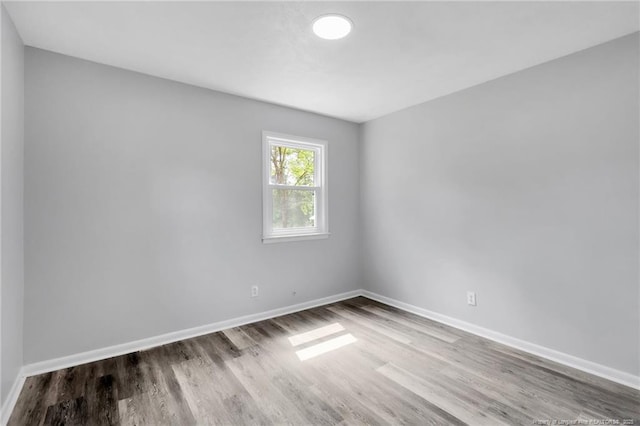 empty room featuring baseboards and wood finished floors