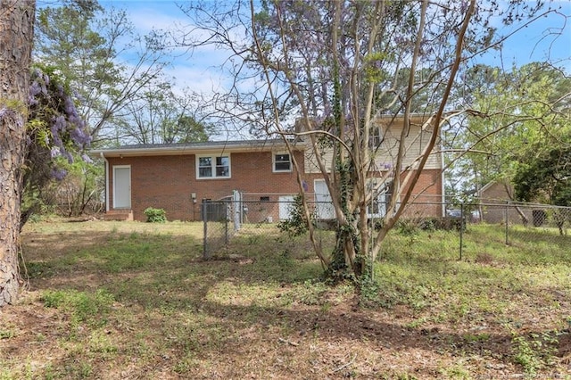 rear view of house with brick siding and fence