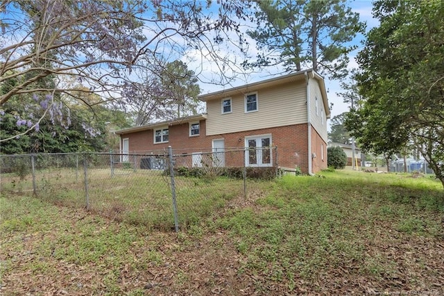rear view of property featuring brick siding and fence