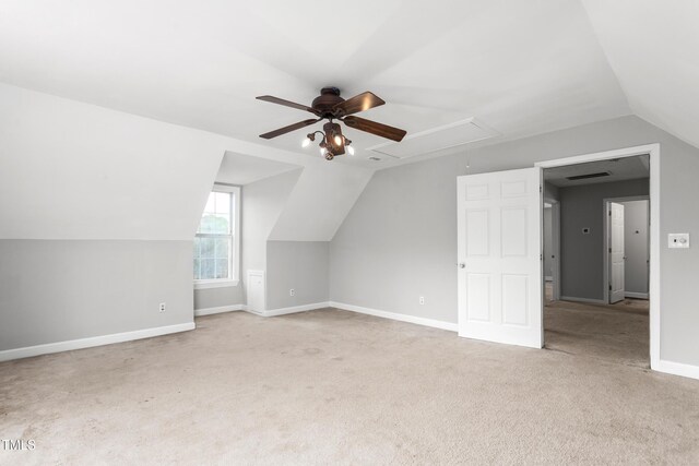 additional living space with attic access, lofted ceiling, baseboards, carpet floors, and ceiling fan