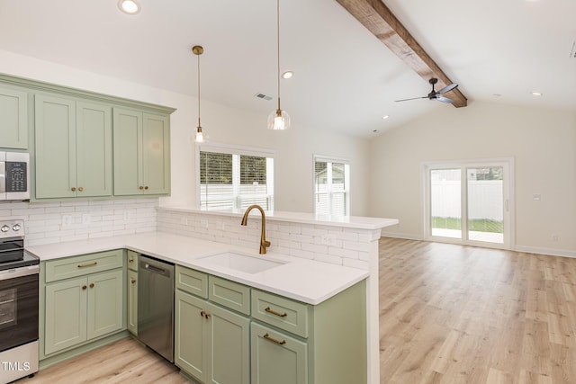 kitchen featuring a peninsula, green cabinetry, stainless steel appliances, and a sink