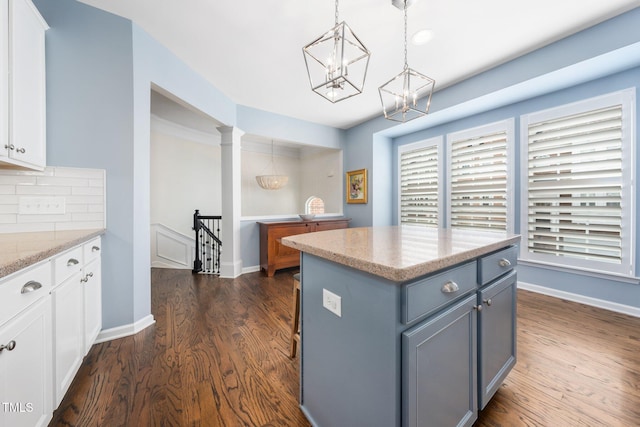 kitchen with dark wood-style floors, white cabinets, and a chandelier