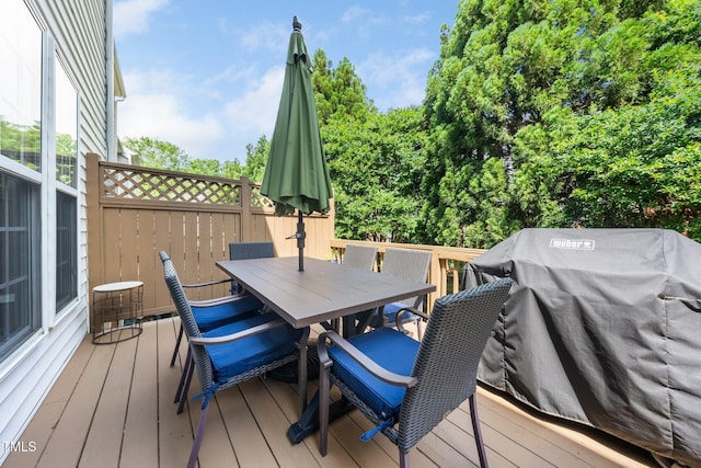 wooden deck with outdoor dining area and grilling area