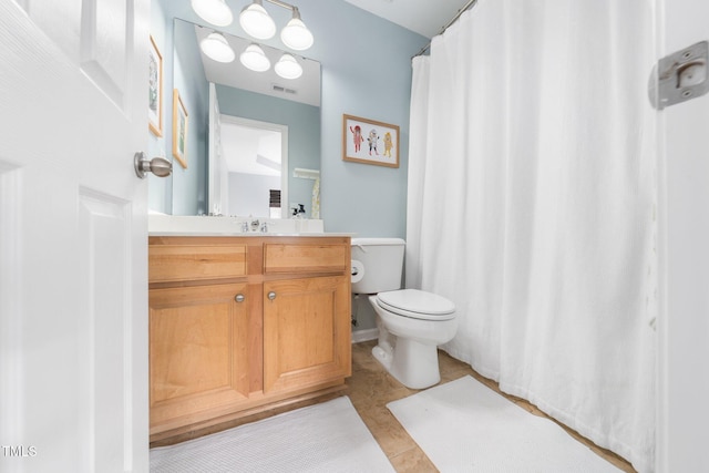 full bathroom featuring toilet, vanity, and tile patterned floors