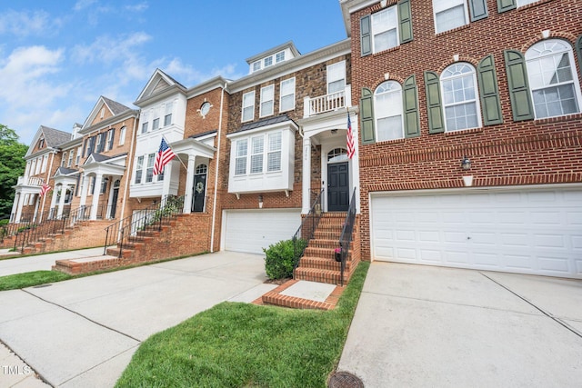 view of front of property featuring an attached garage, concrete driveway, brick siding, and a residential view