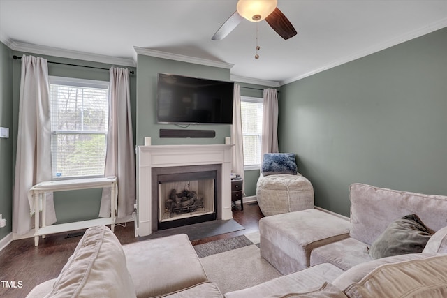 living room with baseboards, wood finished floors, ornamental molding, and a healthy amount of sunlight