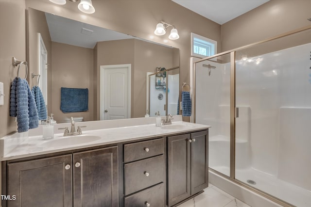 full bathroom featuring a shower stall, double vanity, and a sink