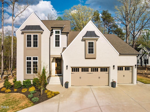 traditional-style house with concrete driveway, a standing seam roof, metal roof, brick siding, and a garage
