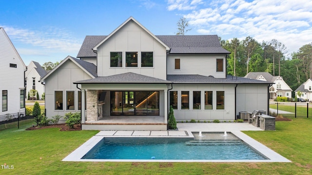 rear view of property with a yard, a patio, and board and batten siding