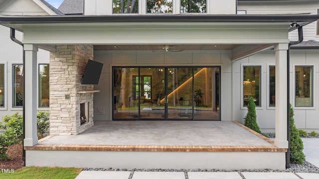 property entrance with ceiling fan, a patio, and an outdoor stone fireplace