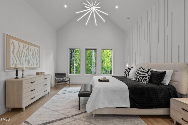 bedroom with light wood-type flooring, a notable chandelier, high vaulted ceiling, and recessed lighting