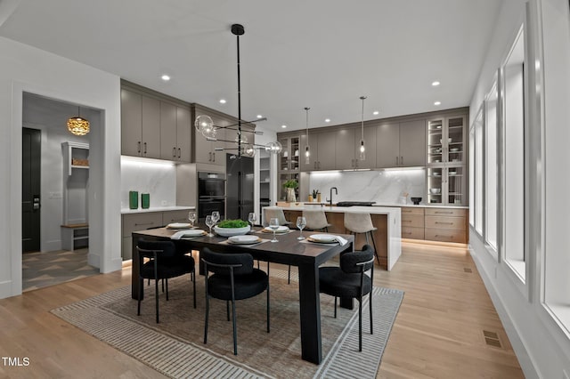 dining space with visible vents, recessed lighting, an inviting chandelier, light wood-style flooring, and baseboards