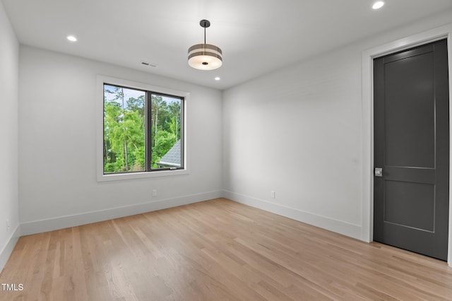 unfurnished room featuring light wood-style floors, visible vents, baseboards, and recessed lighting