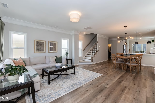 living room with ornamental molding, stairs, plenty of natural light, baseboards, and recessed lighting