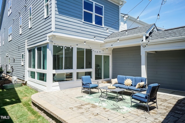 back of property with an outdoor hangout area, a patio area, and a shingled roof