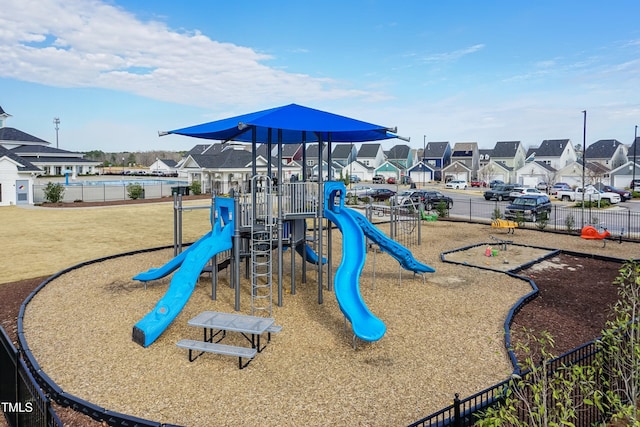 community playground featuring fence and a residential view