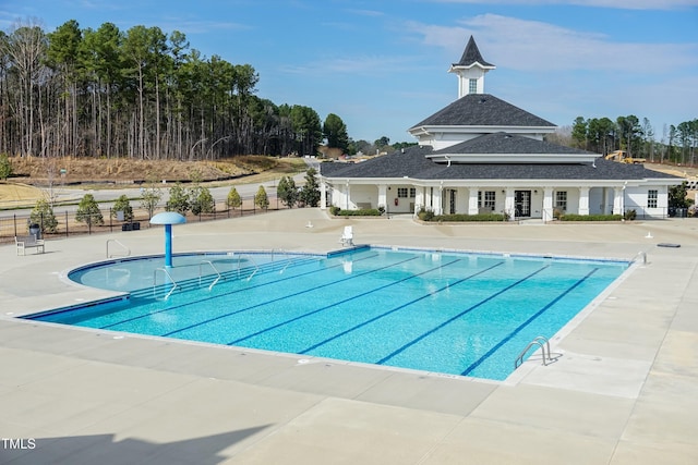 community pool featuring fence and a patio area