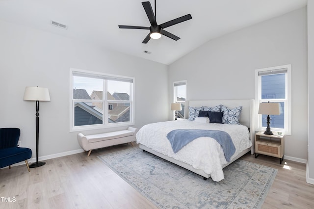 bedroom with light wood-type flooring, lofted ceiling, baseboards, and ceiling fan