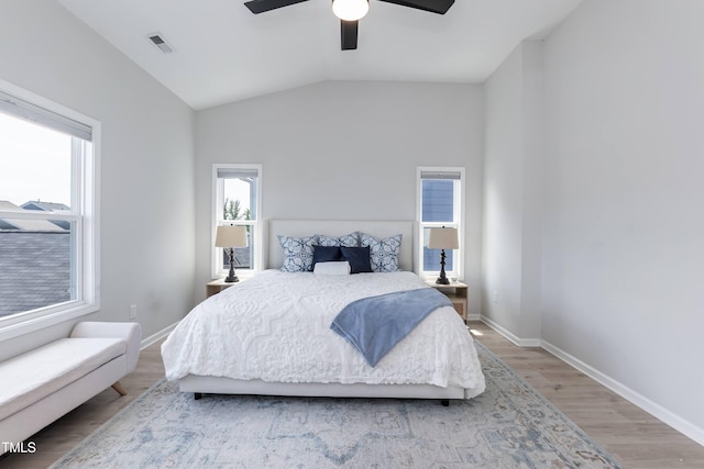 bedroom with light wood-style flooring, baseboards, vaulted ceiling, and ceiling fan