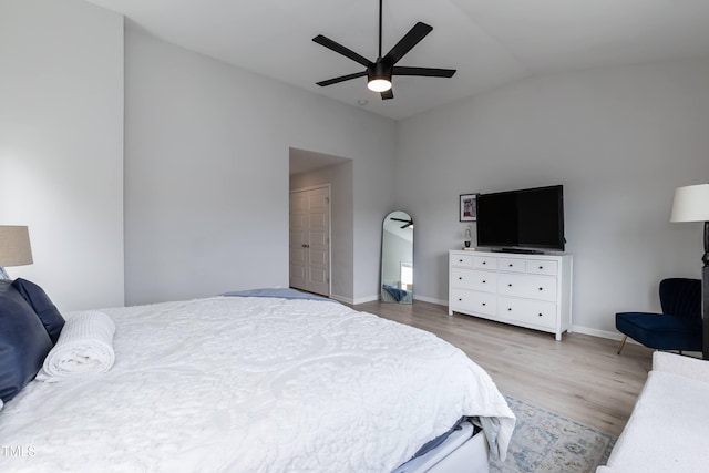 bedroom featuring lofted ceiling, wood finished floors, baseboards, and a ceiling fan