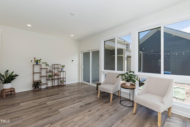 sitting room featuring healthy amount of natural light, wood finished floors, recessed lighting, and baseboards