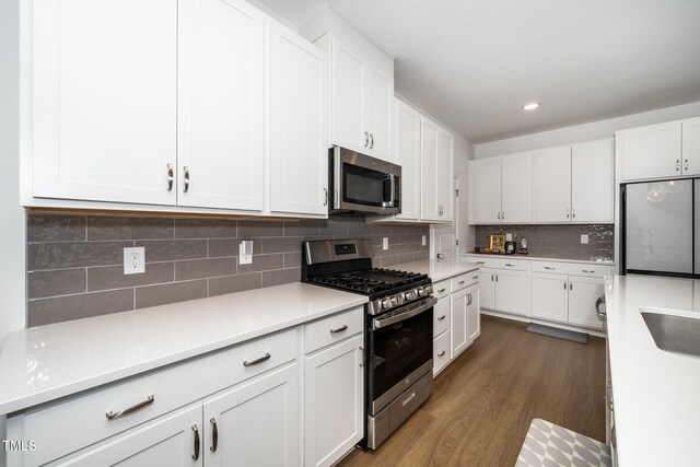 2129 Mars Hill Ln, Apex, NC 27502 - kitchen featuring dark wood-style flooring, light countertops, white cabinetry, stainless steel appliances, and decorative backsplash