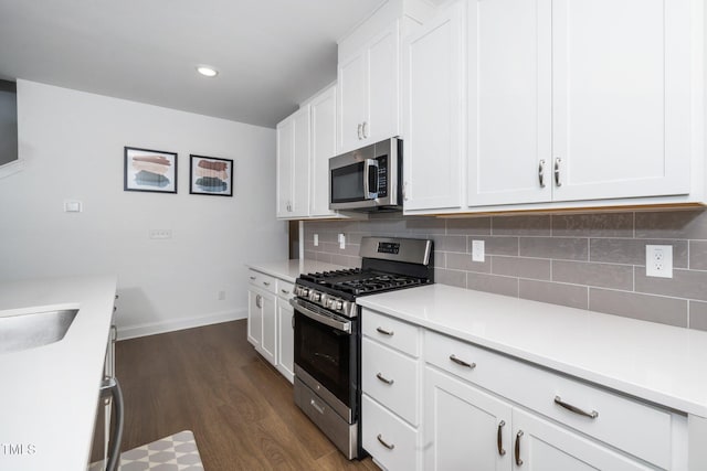 2129 Mars Hill Ln, Apex, NC 27502 - kitchen featuring tasteful backsplash, light countertops, appliances with stainless steel finishes, dark wood finished floors, and white cabinetry