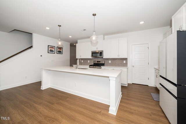 2129 Mars Hill Ln, Apex, NC 27502 - kitchen featuring a sink, light countertops, wood finished floors, stainless steel appliances, and decorative backsplash