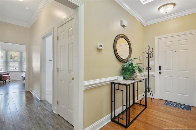 foyer featuring ornamental molding, baseboards, and wood finished floors