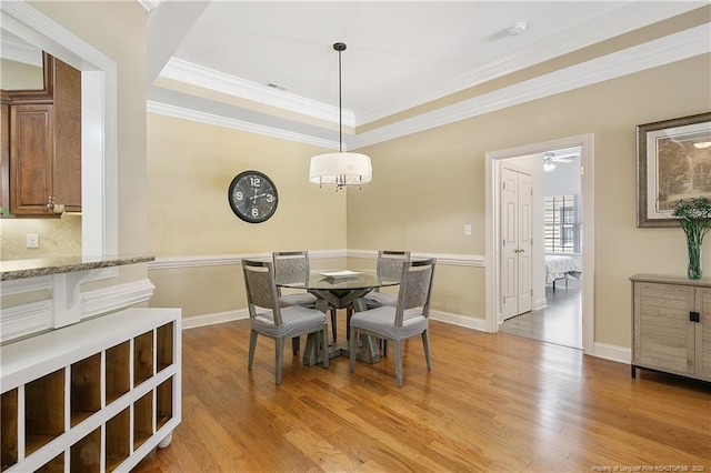 dining space with baseboards, ornamental molding, and light wood-type flooring