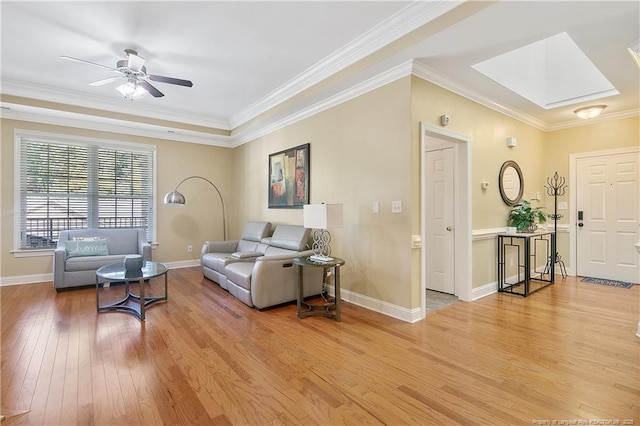 living room featuring light wood-style flooring, crown molding, baseboards, and ceiling fan