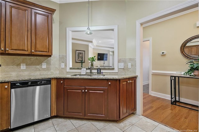 kitchen featuring dishwasher, a sink, crown molding, and light stone counters