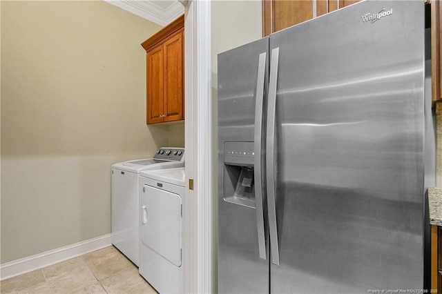 laundry area featuring ornamental molding, baseboards, light tile patterned flooring, cabinet space, and washer and dryer