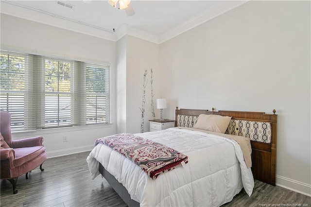 bedroom featuring baseboards, visible vents, crown molding, and wood finished floors