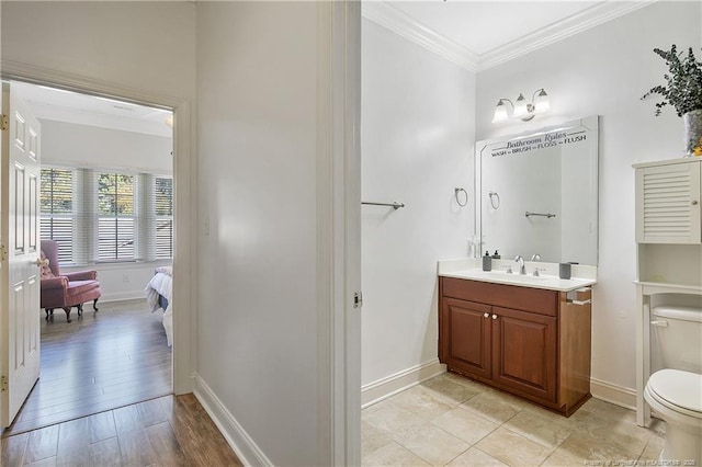 bathroom with baseboards, ornamental molding, toilet, wood finished floors, and vanity
