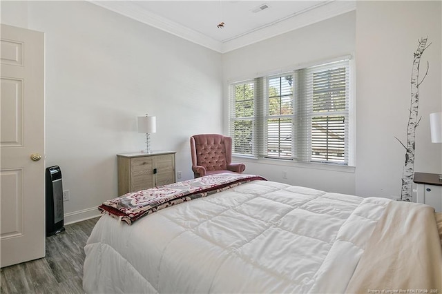 bedroom featuring baseboards, visible vents, crown molding, and wood finished floors