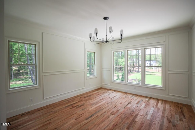 1212 Perry Bluff Dr, Wake Forest, NC 27587 - spare room with a decorative wall, a chandelier, wood finished floors, healthy amount of natural light, and ornamental molding