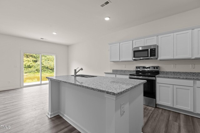 825 Kenyon Spring Dr, Zebulon, NC 27597 - kitchen featuring dark wood finished floors, white cabinetry, a sink, stainless steel appliances, and a center island with sink
