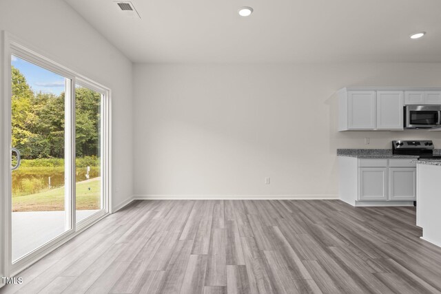 825 Kenyon Spring Dr, Zebulon, NC 27597 - unfurnished living room featuring recessed lighting, light wood-style flooring, baseboards, and visible vents