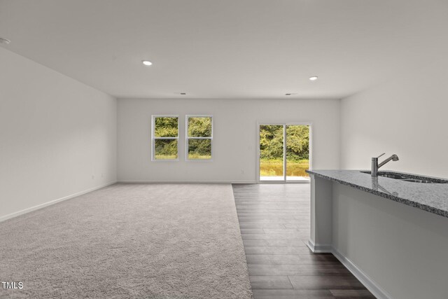 825 Kenyon Spring Dr, Zebulon, NC 27597 - unfurnished living room featuring a sink, baseboards, recessed lighting, and dark wood-type flooring