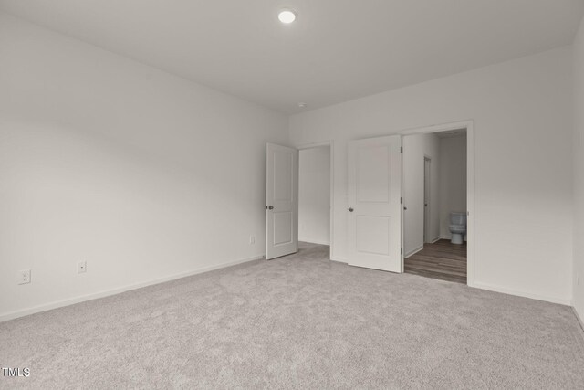 825 Kenyon Spring Dr, Zebulon, NC 27597 - unfurnished bedroom with carpet floors, baseboards, and connected bathroom