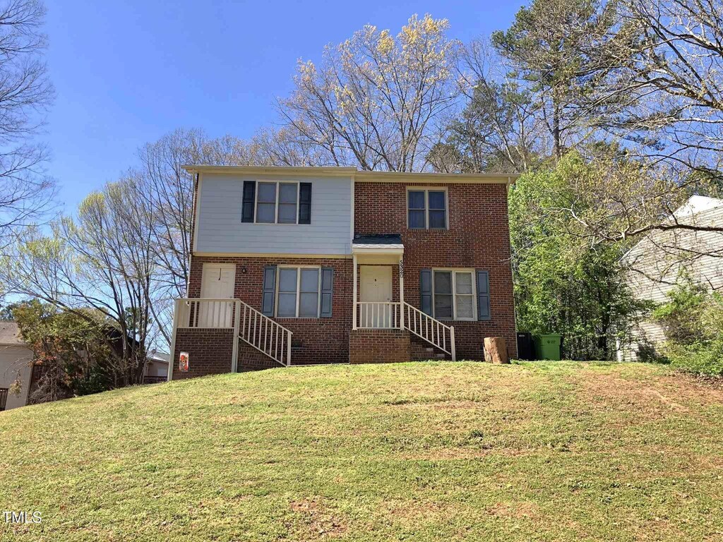 view of front of house with brick siding and a front yard