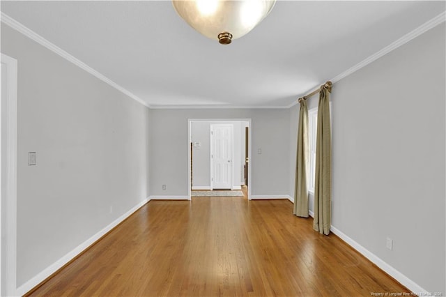 unfurnished room featuring ornamental molding, baseboards, and wood finished floors