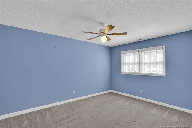 carpeted empty room with a textured ceiling, baseboards, ceiling fan, and visible vents